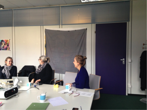 Sarah Greifenstein, Lynne Cameron, and Cornelia Müller in front of the concealed artwork.